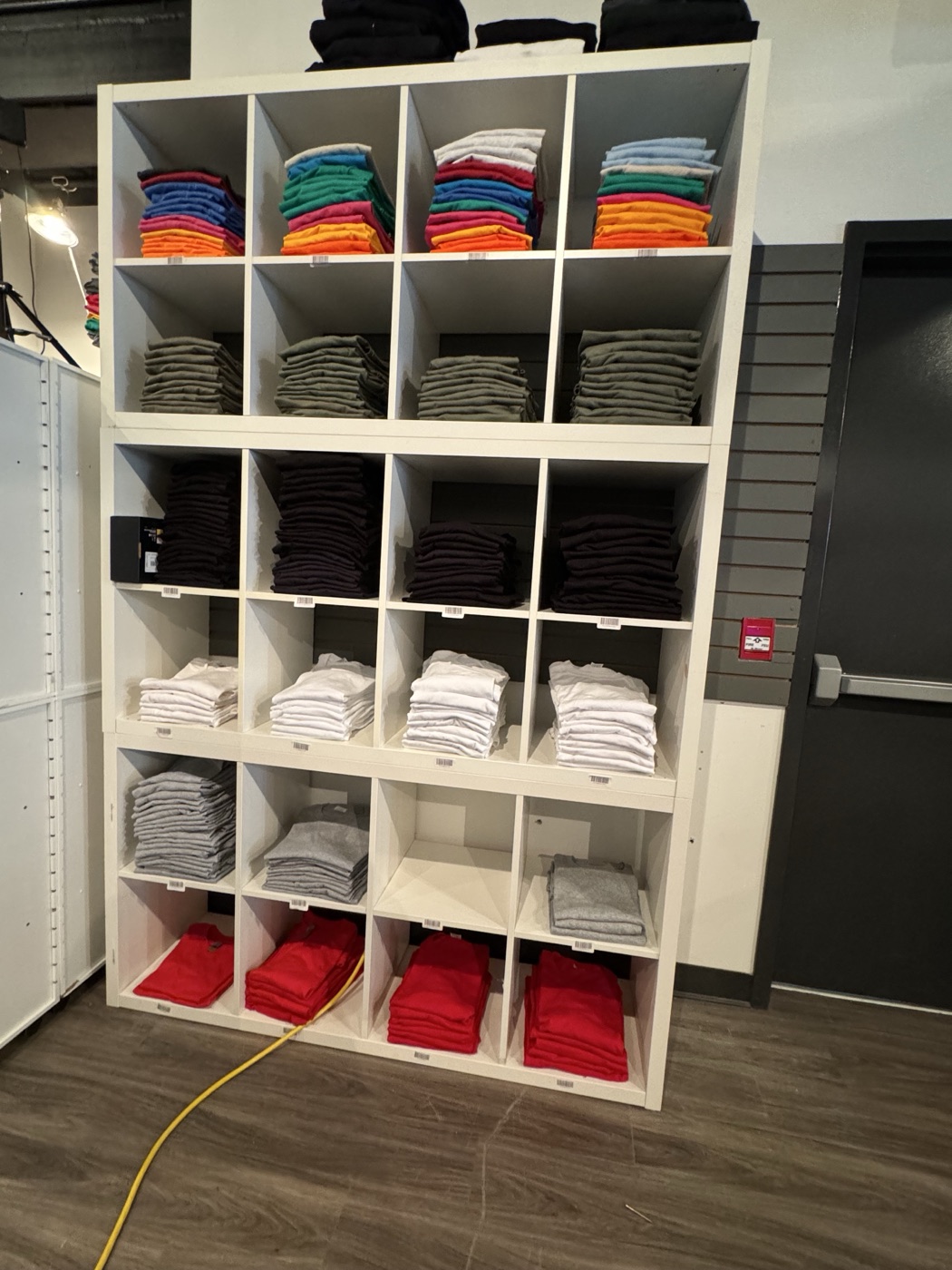 Blank apparel stock organized for custom printing at The RAD Studio in Stratford Ontario